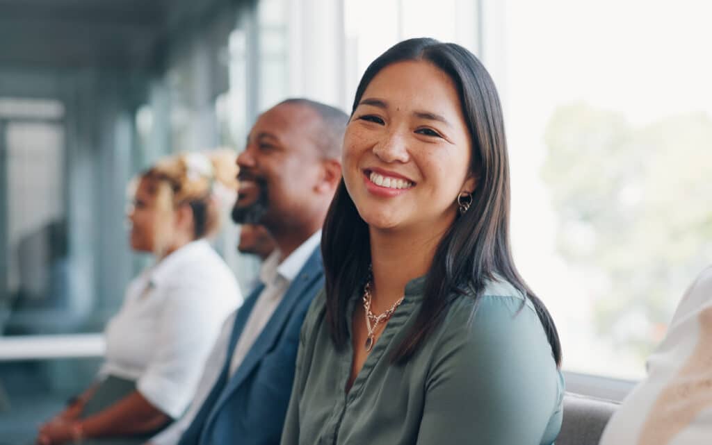 Face, recruitment or business people in a waiting room for a job interview at human resources office building. Portrait, we are hiring or excited woman in queue for an advertising agency or company.