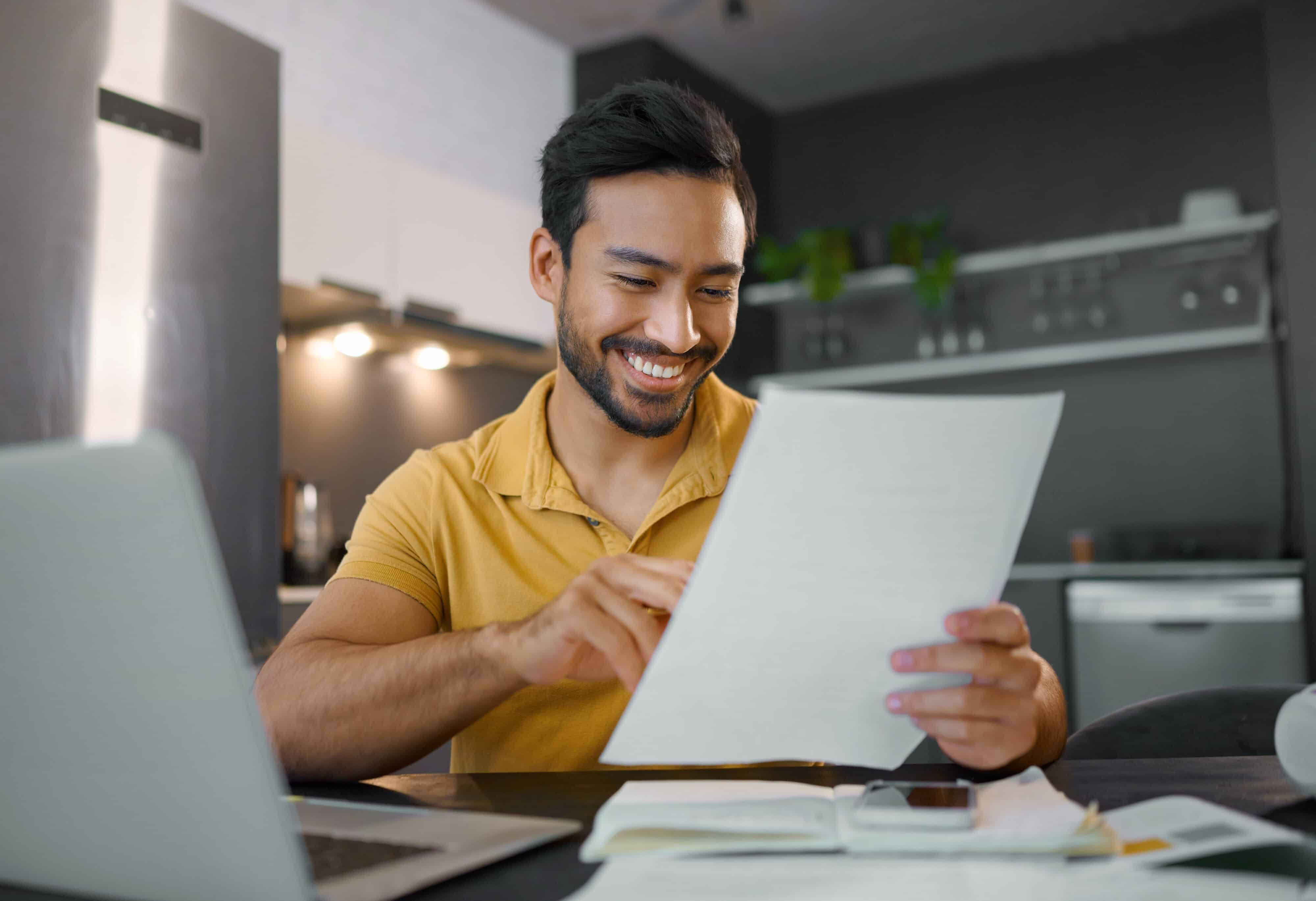 Planning, smile and Asian man with paperwork and a laptop for finance budget, entrepreneurship and tax. Happy, summary and freelancer reading the proposal of a project, financial deal or report