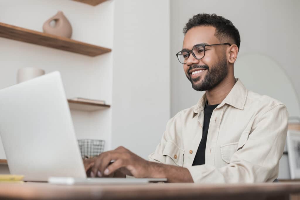 Young man student using laptop computer at home studying online. Creative professional working in office. Distance study, work from home, e learning, business, meeting online